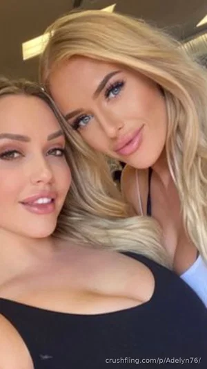 Two women with blonde hair in a close selfie, one in a black top, indoors.