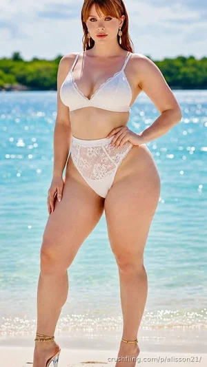 Woman in white lace bikini standing on beach near water, curvy figure, outdoor setting.