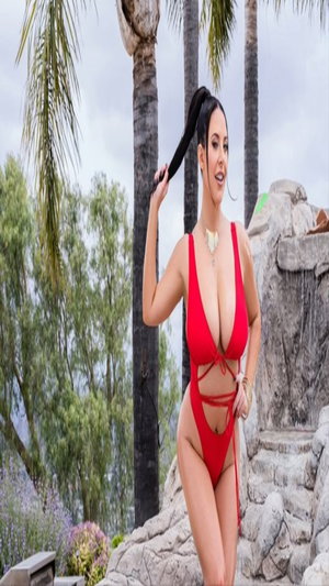 Curvy woman in red swimsuit posing outdoors near palm trees.