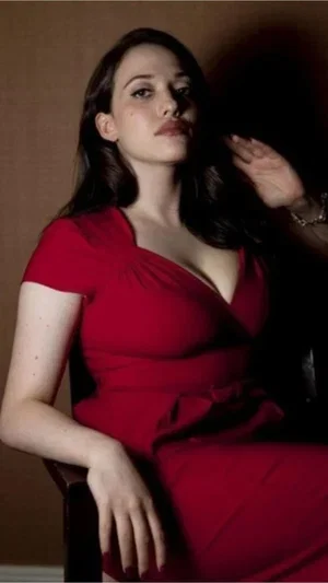 Woman in red dress posing indoors, dark hair, elegant lighting.