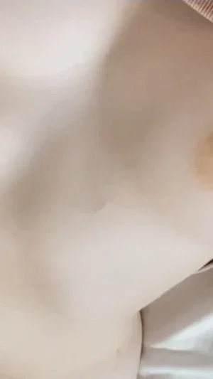 Close-up of skin under white fabric on bed.