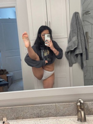 Woman in white underwear and gray crop hoodie poses in bathroom mirror selfie.