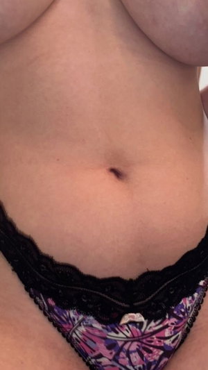 Woman in black lace and patterned underwear, showing midriff and lower abdomen.