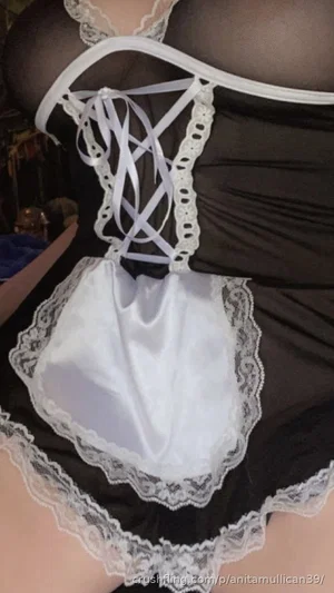 Woman in black lace lingerie with white satin front, indoor setting.