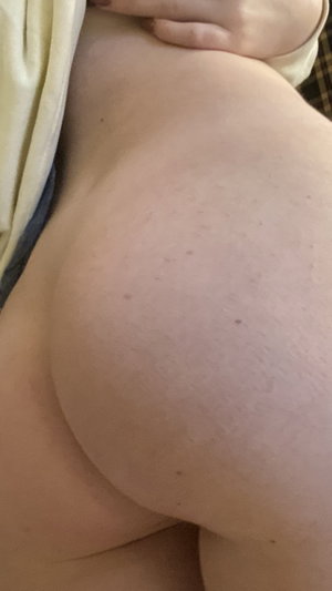 Curvy person lying down with bare buttocks partially covered by fabric.
