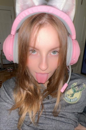 Woman with long brown hair in pink cat-ear headphones and grey sweatshirt.