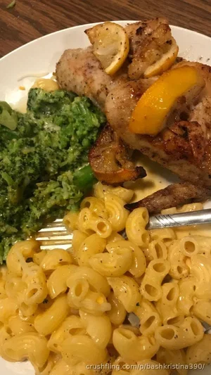 Plate of macaroni and cheese, grilled chicken with lemon, and steamed broccoli.