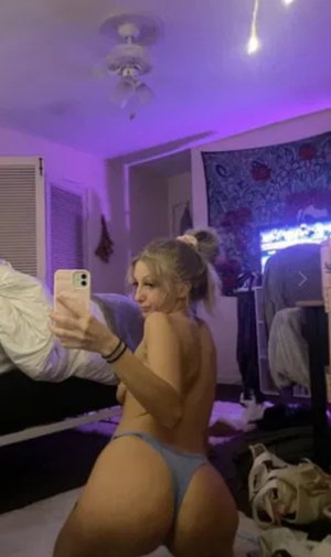 Blonde woman in blue underwear taking selfie in bedroom.