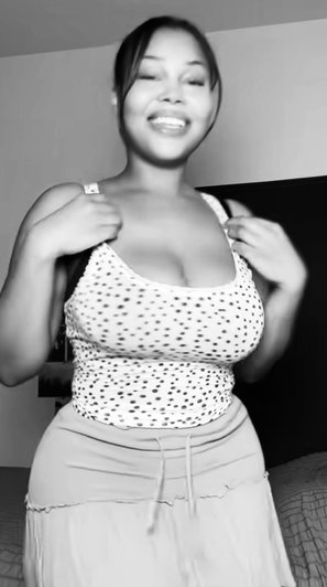 Woman in polka dot top adjusting straps indoors.