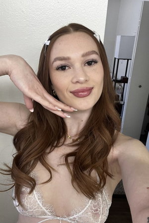 Slim redhead in white lace lingerie, indoor selfie.