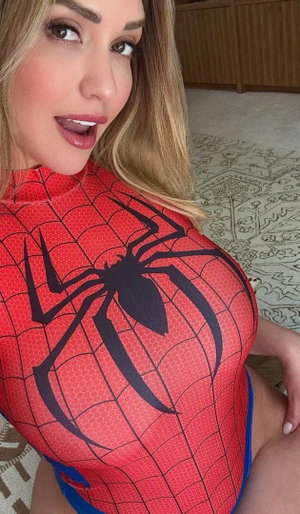 Blonde woman in Spider-Man costume posing indoors.