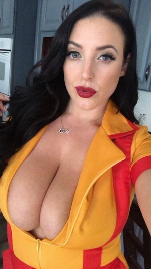Woman with long dark hair in yellow and red outfit, posing indoors.