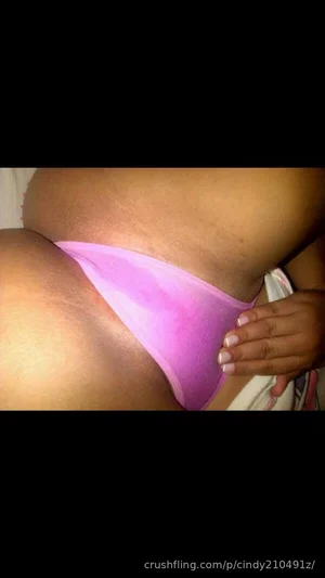 Woman in pink thong, curvy body, indoor setting, hand on hip.