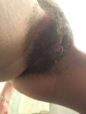 Close-up of a man's neck and ear with short dark hair, indoors.