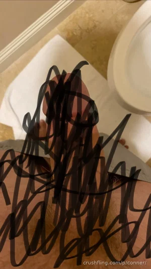 Person in bathroom with black scribbles covering body, towel and toilet visible.
