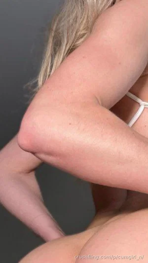 Blonde woman in white lingerie, close-up of arm and hip, indoor setting.