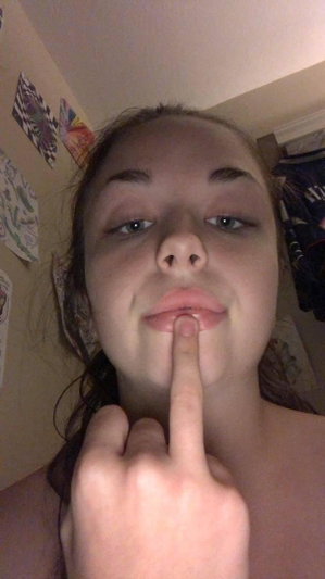 Brunette woman taking close-up selfie indoors.