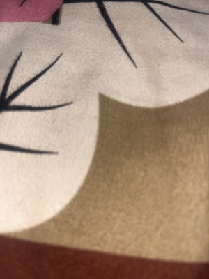 Close-up of fabric with cartoon eyes and pink detail, possibly clothing or bedding.