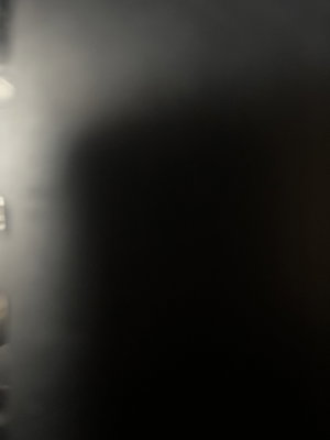Dark, blurry image with no clear person or object visible.