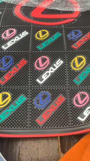 Colorful Lexus floor mats on wooden surface.