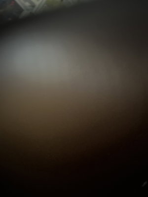 Blurred close-up of skin tone, possibly body part, indistinct setting.