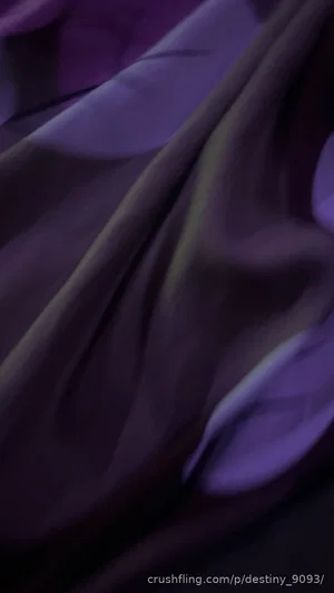 Close-up of purple fabric with soft folds and highlights.