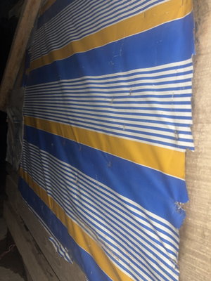 Blue and yellow striped fabric hanging in rustic setting.