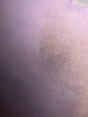 Textured purple wall with scratches and wear marks.