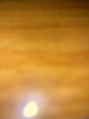 Blurry wooden surface with bright light reflection.
