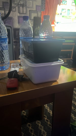 Table with water bottles, food containers, keys, pills.
