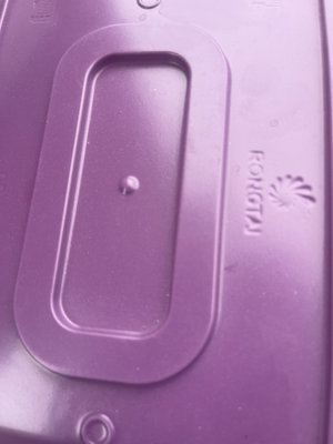 Close-up of purple plastic lid with oval slot.