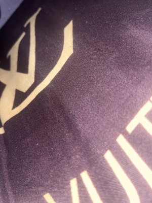 Close-up of dark fabric with gold logo.
