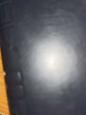 Blurry dark image with light reflection, no person visible.