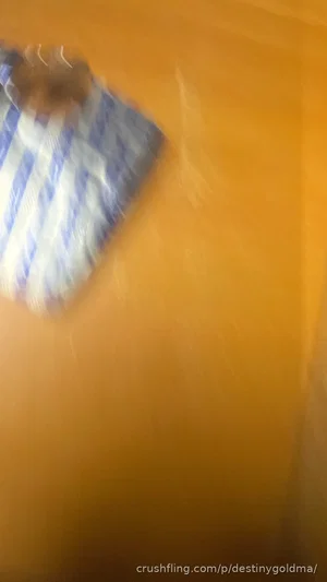 Blurry image of a person with light skin and blue-and-white striped fabric, possibly a shirt, on an