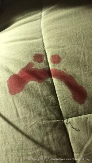 Close-up of fabric with red stains and a small metal clasp.