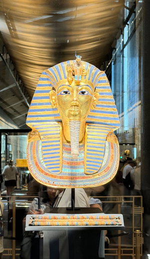 Golden Egyptian pharaoh mask on display in museum.