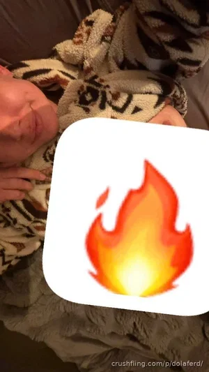 Person lying on a patterned blanket, face partially visible, covered by a flame graphic.