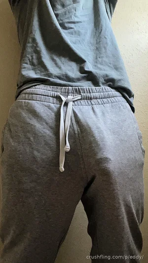 Person in gray sweatpants and t-shirt, back view, indoor setting.