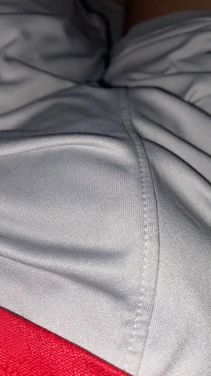 Close-up of gray fabric with red trim, possibly clothing or bedding.