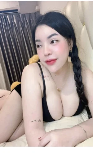 Curvy Asian woman in black lingerie on bed.