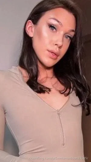 Woman with dark hair in a beige zip-front top, indoors, looking at camera.