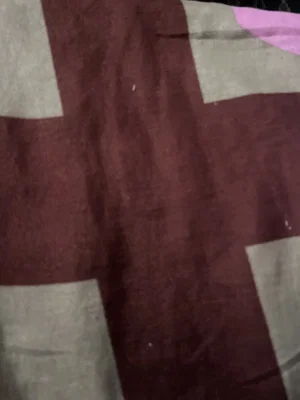 Close-up of a maroon and beige patterned fabric, possibly a blanket or towel.