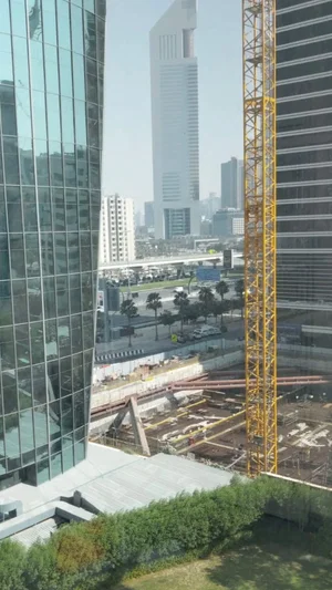 Cityscape with tall buildings, construction site, and crane in urban area.