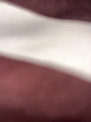 Close-up of skin and white fabric, possibly underwear or sheet, blurred image.