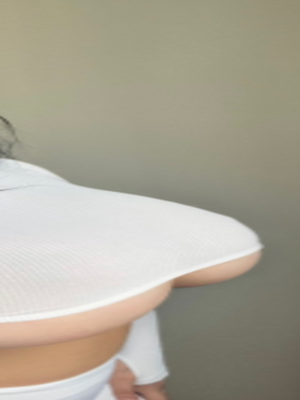 Woman in white crop top posing indoors.