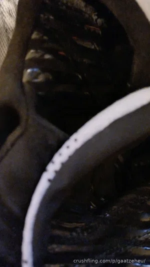 Close-up of black athletic shoes with white soles, indoors.