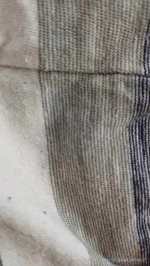 Close-up of textured fabric with striped pattern, possibly clothing.