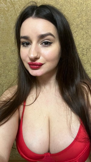 Woman with long dark hair wearing red bra indoors.