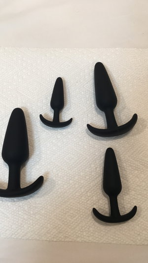 No person; black butt plugs on paper towel.