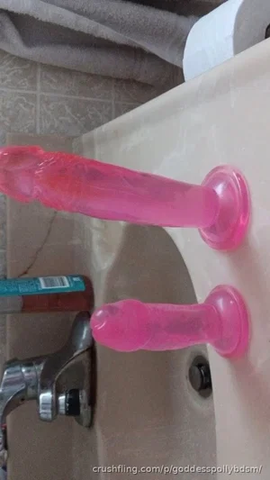 Two pink silicone dildos on a bathroom sink counter.